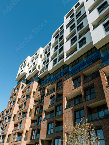 Contemporary residential architecture featuring brick and glass elements under a clear blue sky in South Spain, ideal for real estate, urban living, and property investment visuals.