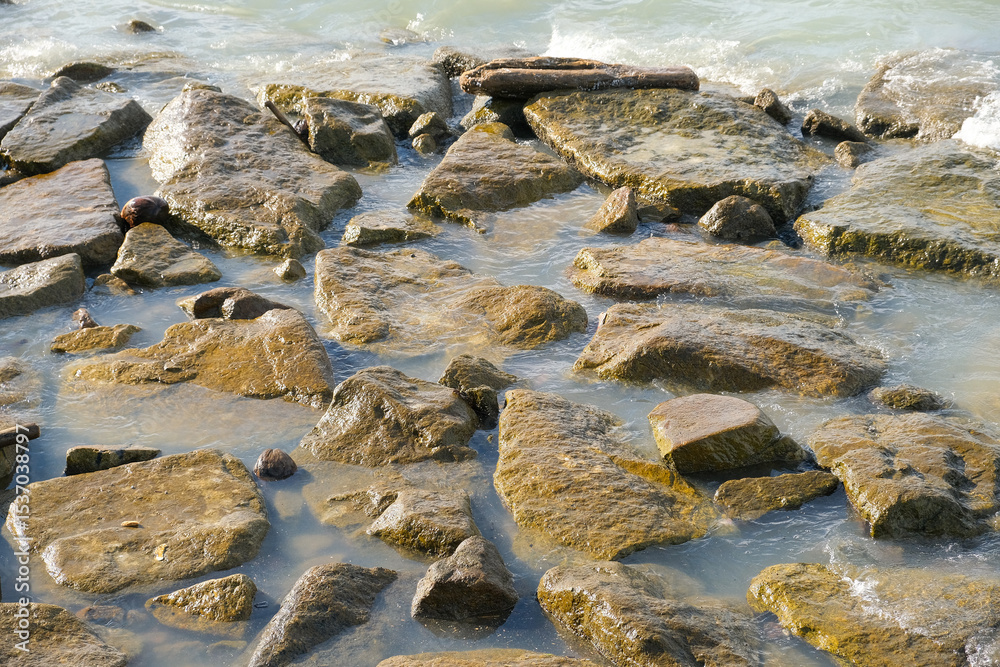 Obraz premium Coastal Rocks Partially Submerged by Sea Water in George Town, Penang, Malaysia.