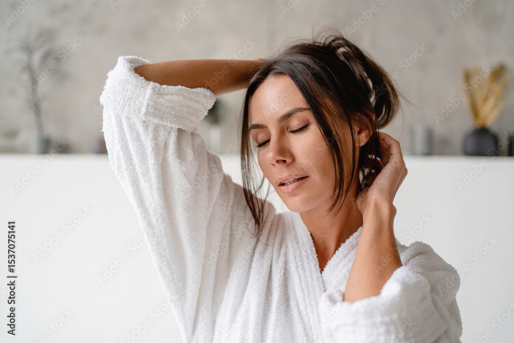 Smiling beauty Caucasian brunette woman in white silky bathrobe posing at white bathroom, smiling at camera closed eyes, closeup portrait, panorama with copy space. Face and skin care at home concept Smiling beauty Caucasian brunette woman in white silky bathrobe posing at white bathroom, smiling at camera closed eyes, closeup portrait, panorama with copy space. Face and skin care at home concept