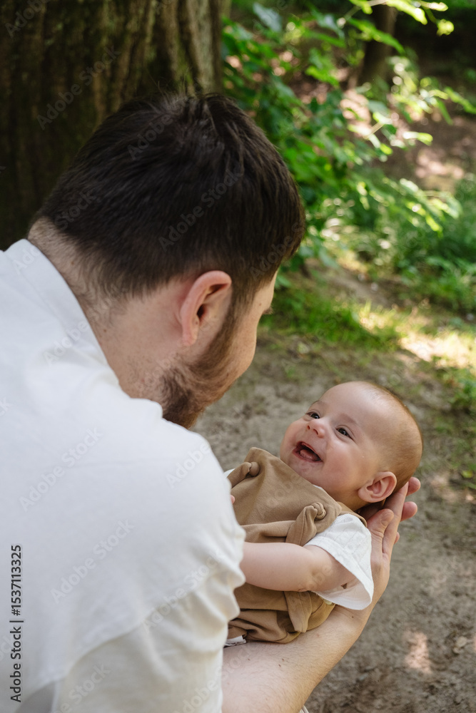 Fototapeta premium Father Holding Baby in Sunny Park