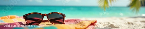 Relaxing Caribbean beach scene with stylish sunglasses left on a vibrant towel, sun shining, turquoise water visible in the background , sunshine, sun