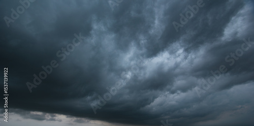 A dense, dark sky filled with swirling storm clouds signals an intense windstorm, emphasizing the power and drama of nature's environment in turbulent weather conditions.