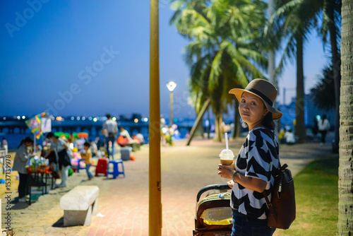 An Asian woman enjoying the local nightlife at the seaside in Zhanjiang, Guangdong, China