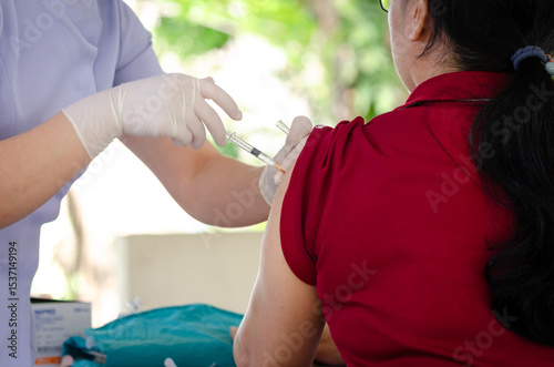 Concept of vaccination against epidemic, woman wearing medical face mask is getting vaccinated against epidemic at hospital medical center