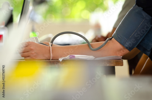 Annual checkup concept. Doctor is measuring patient's blood pressure. The patient has a blood pressure cuff on his arm.