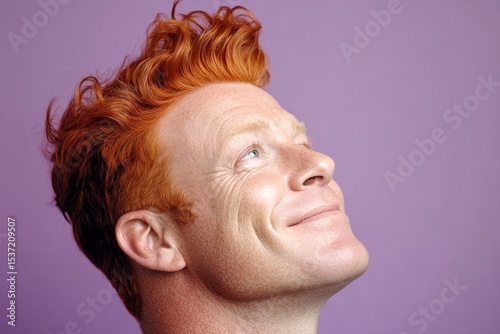 Modish men's ivy league haircut - midlife white man with red hair. A vibrant male with a lively and glowing personality. Creative of style for aging men. Purple solid background.