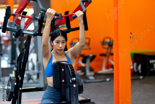 Young woman's fitness exercise with dumbbells gym equipment in the gym promotes a healthy lifestyle