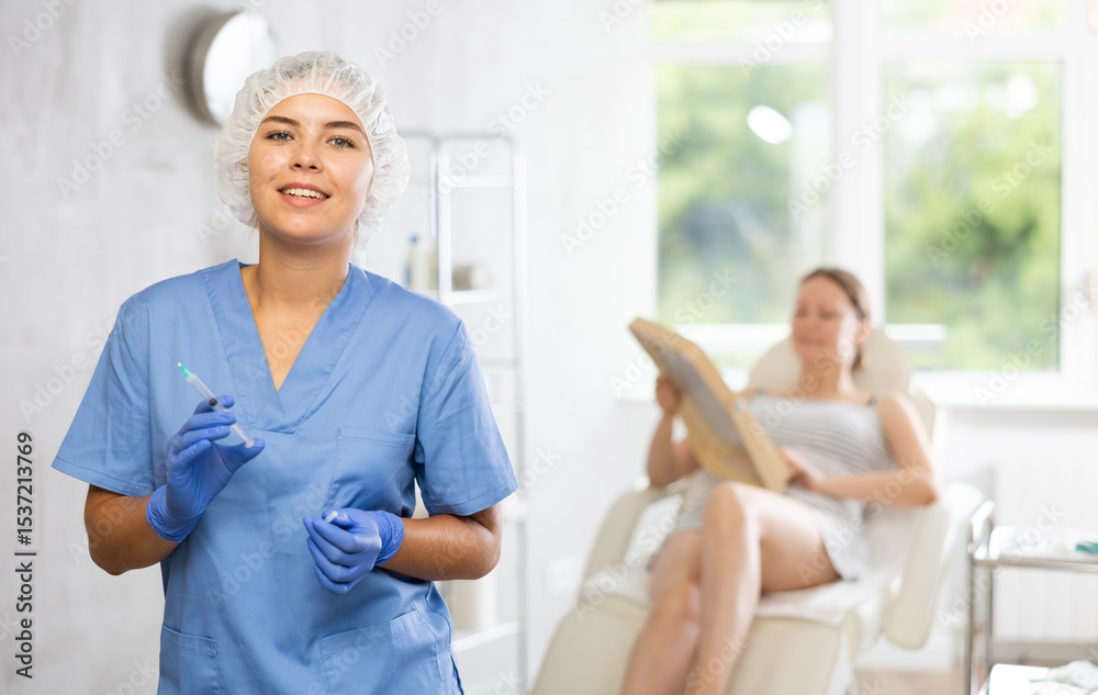Obraz premium Young woman doctor cosmetologist holds syringe in medical office