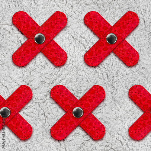 Seamless 4k photo texture material of white colored leather with red cross inserts.