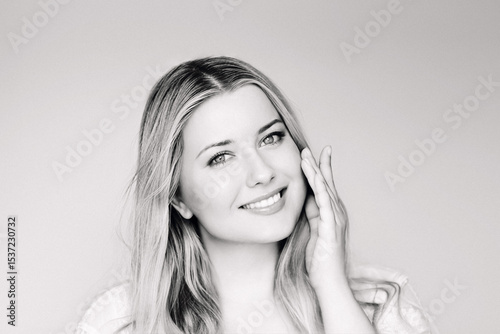 Natural beauty, skincare and cosmetics, smiling blonde woman with blue eyes and radiant face applying moisturiser, light classic elegant monochrome portrait