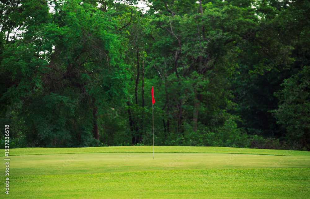 Obraz premium Golf Course Green Field with Red Flag on Putting Green in Summer for Outdoor Sport, Nature, and Tranquil Scenery