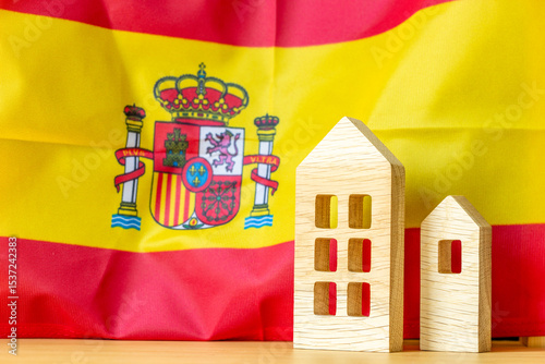 Wallpaper Mural Spanish real estate. Wooden miniatures of houses against the backdrop of the Spanish flag. Economic business concept. Rising housing prices. Rising rental costs. Spain's economic problem Torontodigital.ca