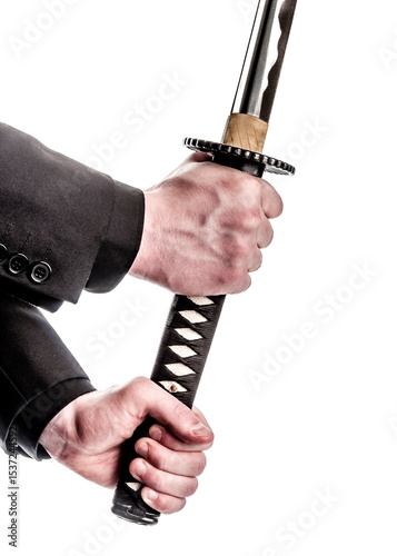 A person in a suit holding a katana sword.