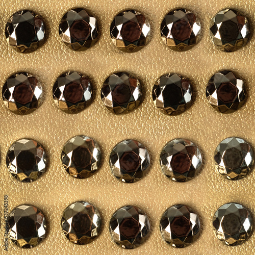 Seamless 4k photo texture material of golden colored leather surface with metal studs.