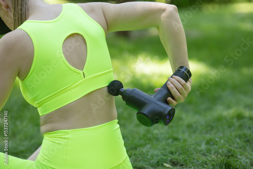 Athletes physical therapy. Massage gun, handheld cordless professional percussion deep Tissue body muscle fascia Massager for athletes.  Outdoor activity.