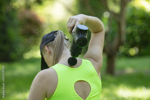 Athletes physical therapy. Massage gun, handheld cordless professional percussion deep Tissue body muscle fascia Massager for athletes.  Outdoor activity.