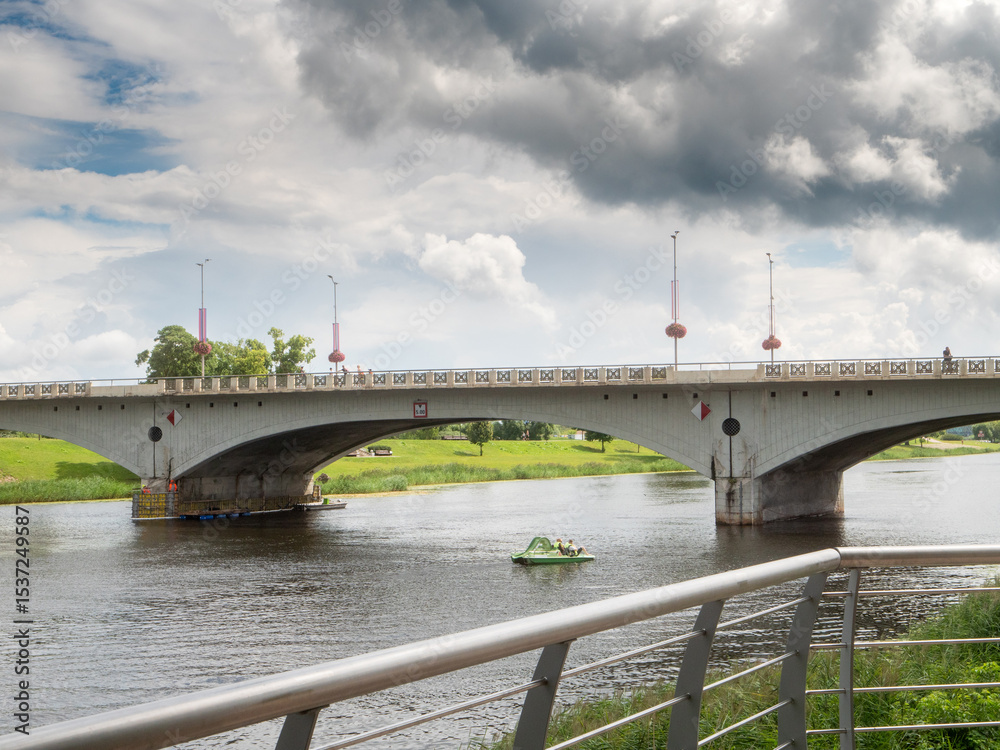 Old bridge over river Lielupe, Jelgava, Latvia, warm sunny day, cloudy sky. Town architecture. Old bridge over river Lielupe, Jelgava, Latvia, warm sunny day, cloudy sky. Town architecture.