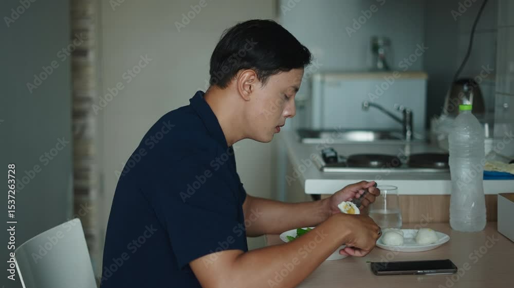 Adult Man Enjoying Nutritious Meal Based On Hard-Boiled Eggs With Fresh Vegetables In A Modern Kitchen