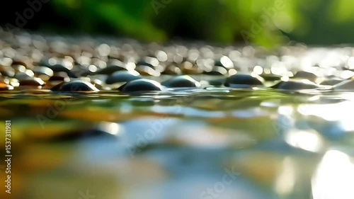 Close up of water droplets on a surface of rocks, with green foliage visible in the background