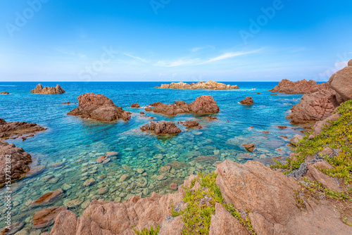 Fototapeta Naklejka Na Ścianę i Meble -  Rocky coastline meets crystal-clear turquoise water, creating a serene seascape. Sardinia
