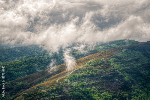 Morning fog rises to form low clouds over the mountains