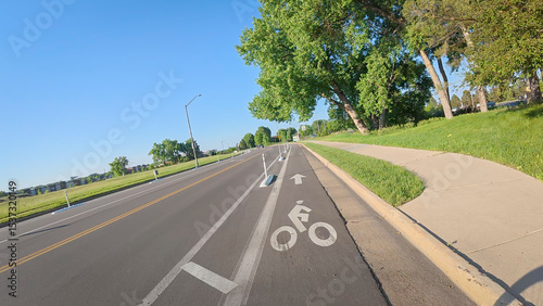Bike lane separated from a car traffic on a street in Fort Collins, Colorado - biking POV
