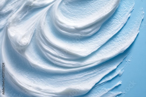 White Cream Smears on Blue Background Depicting Skincare and Moisturizing, Highlighting Texture and Care Routines, Concept of Cosmetics and Beauty Products