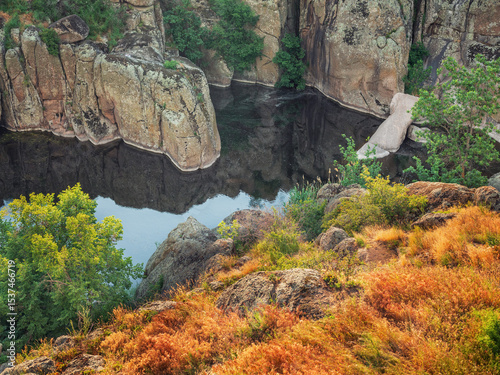 view to canyon river between granite cliffs and golden grass on banks from high point