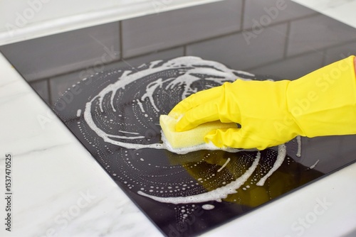 Woman cleaning modern hob. Housekeeping.