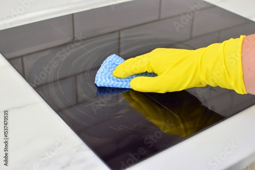 Woman cleaning modern hob. Housekeeping.