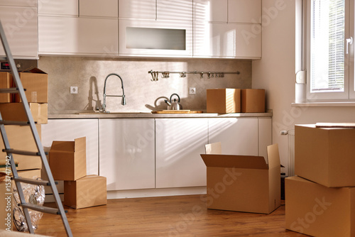 Papier peint Bright kitchen filled with unpacked boxes and moving supplies