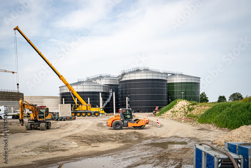 Aufstellen von großen Betonteilen mit einem Baukran für den Bau einer Industriehalle und Biogasanlage.