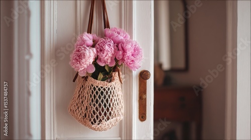 Beautiful Bouquet of Pink Peonies in a Woven Bag by the Door in a Cozy Interi...