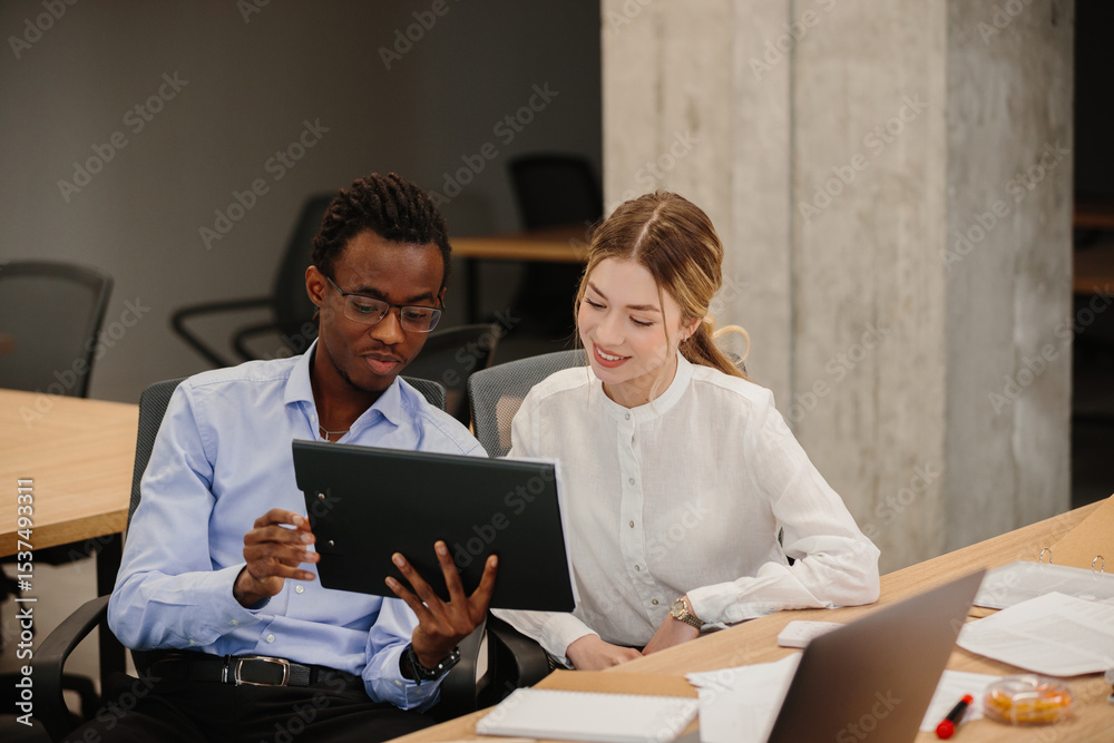 Business colleagues collaborating on project using tablet in office Business colleagues collaborating on project using tablet in office
