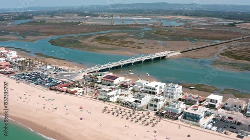 Aerial panorama revealing faro beach, historic bridge, and ria formosa natural park, showcasing stunning lagoon landscape within algarve region's coastal environment of southern portugal