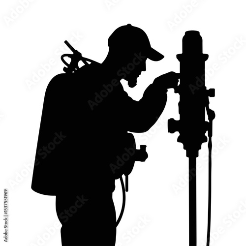 Silhouette of a male worker adjusting equipment with a tool in hand against a stark white background, industrial maintenance concept of service or technical support.