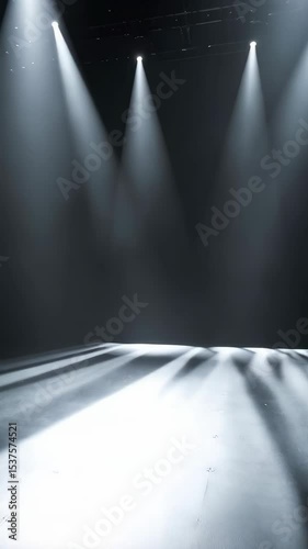 Stage lighting with four bright spotlights shining onto a dark concrete floor creating a dramatic and atmospheric scene for performance