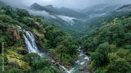   Waterfall amidst woods, peak range, cloudy sky
