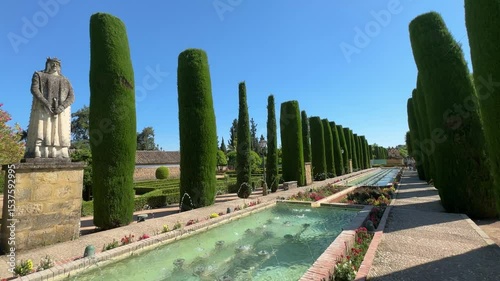 Cordoba, Spain - Alcazar gardens in Cordoba, Spain, Jardines del Alcazar de los Reyes Cristianos, water fountain with statue of king and queen and Christopher Columbus