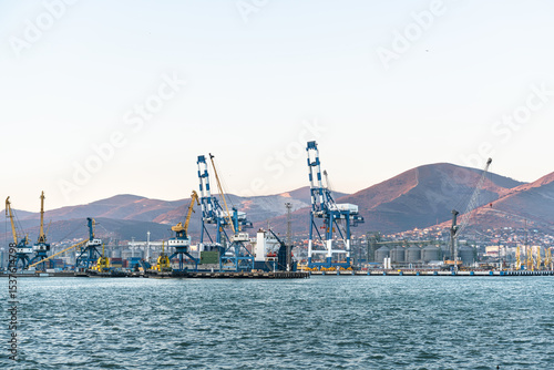 Seaport with tugboats and industrial cranes, Novorossiysk, Russia. The Black Sea. Silhouettes of the seaport