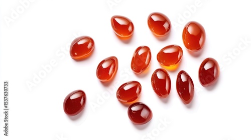 Collection of small, glossy, red/orange, droplet-shaped gems scattered on white