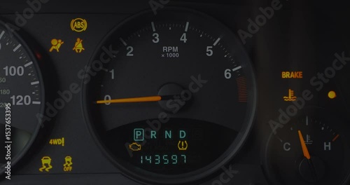 Close-up of car dashboard with multiple warning lights activated, including ABS, airbag, seatbelt, brake, 4WD, and tire pressure. Gear in Drive, RPM at idle. Vehicle maintenance concept. 