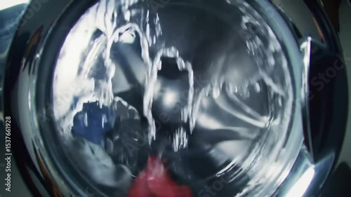 A washing machine with clothes spinning inside during a laundry cycle