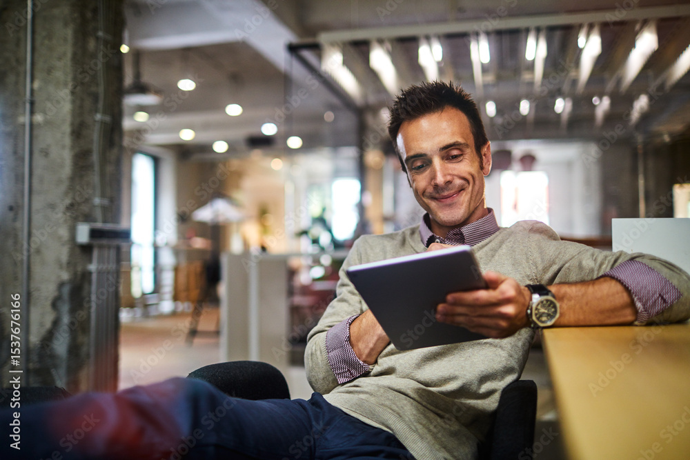 Fototapeta premium Confident young man working on a digital tablet in a modern office setting