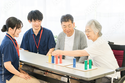 介護施設・リハビリ施設で働く作業療法士の職員とリハビリをするシニア女性
