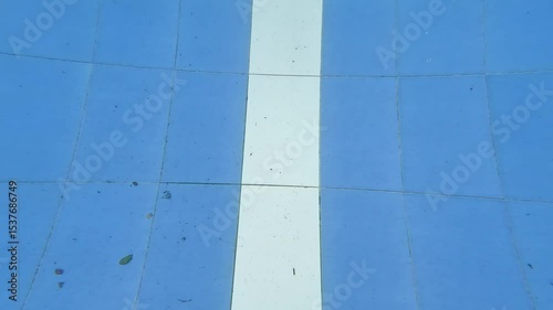 Single man do aqua running in the swimming pool with blue and white ceramic