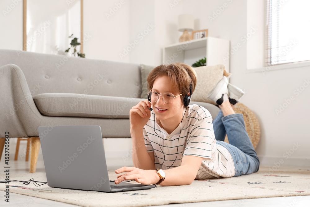 Teenage boy with laptop and headset working online at home Teenage boy with laptop and headset working online at home