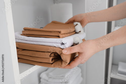 Female hands putting stack ...
