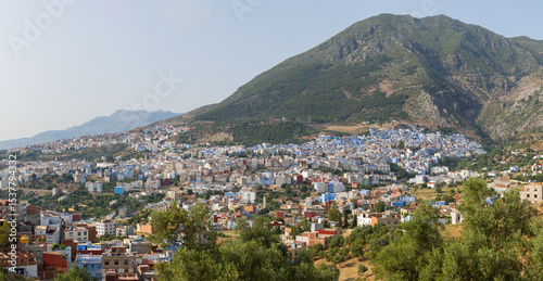 Elevated sunset panoramic views of the blue city of Chefchaouan located in the Rif Mountains of northwest Morocco