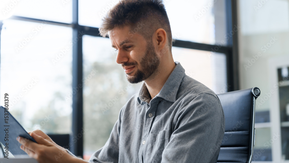 Fototapeta premium A smart Caucasian businessman sits confidently at desk in modern indoor office, using laptop for online consulting, showcasing professionalism, success, digital expertise in corporate environment.